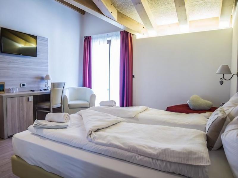Camera accogliente con letto morbido, luce calda e arredi eleganti.